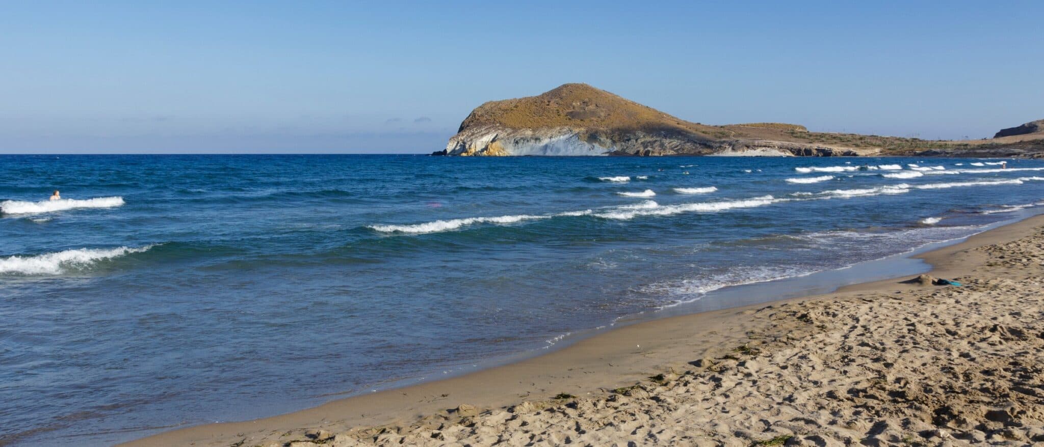 The empty beach at Playa de los Genoveses in Cabo de Gata, Almería, with the volcanic headland behind