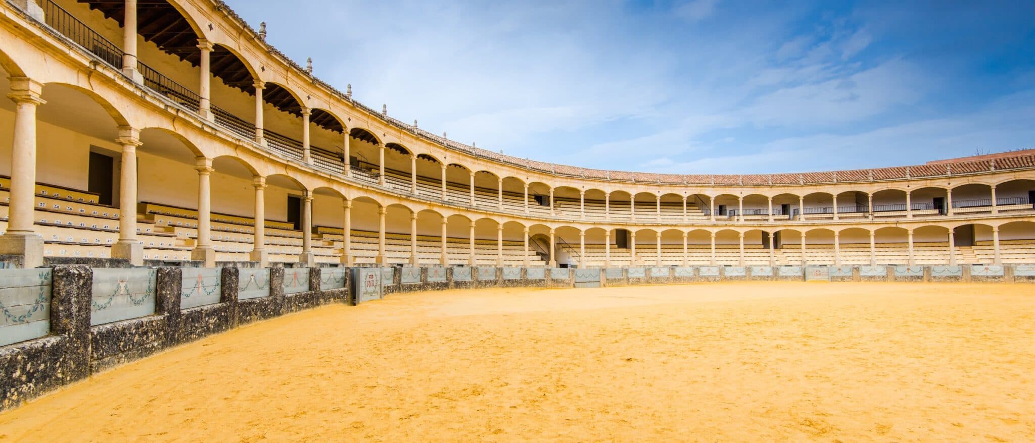 The eighteenth-century bullring at Ronda, its double arcade of stone columns around the empty sand