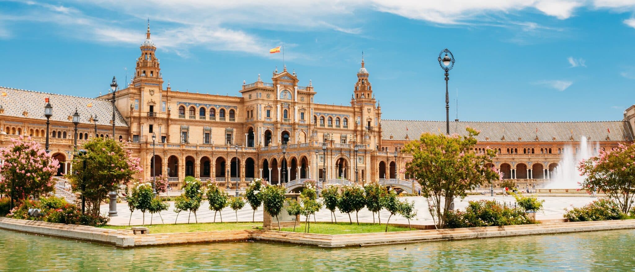 Plaza de España in Seville seen across the canal, with the fountain and the brick arcades