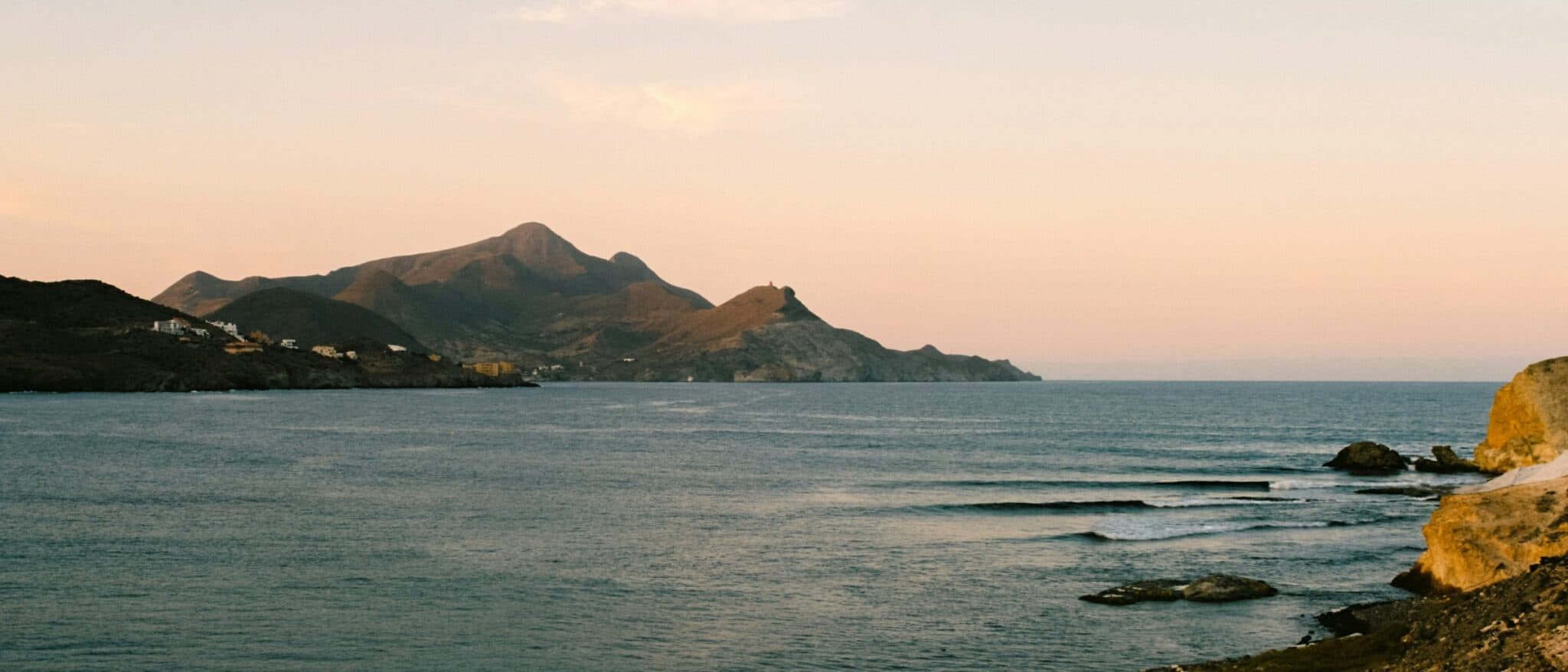 The arid volcanic headlands and empty sea of the Cabo de Gata coast in Almería at dusk