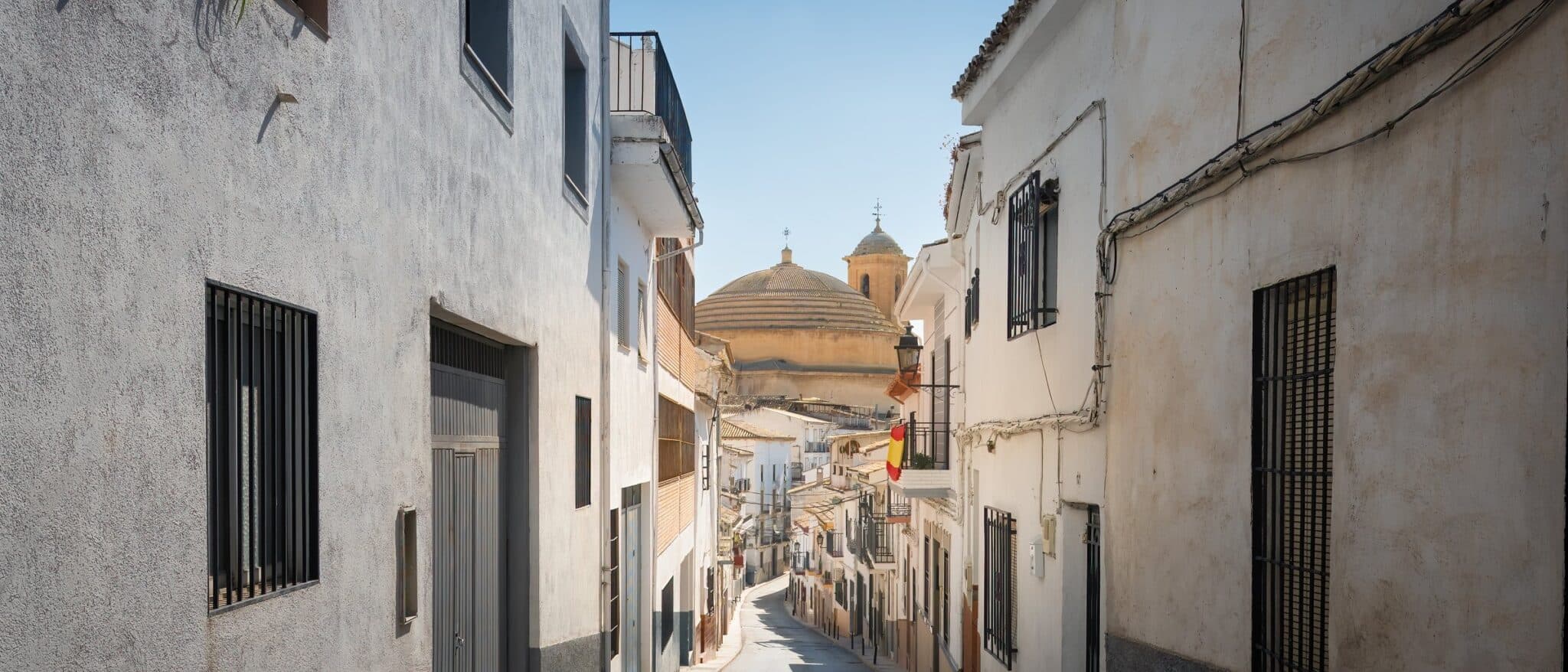A steep street in Montefrío, Granada province, ending at the domed church